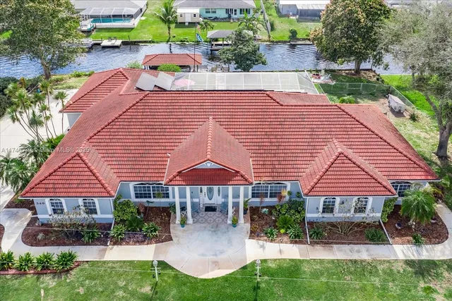 an aerial view of a house with yard and a patio