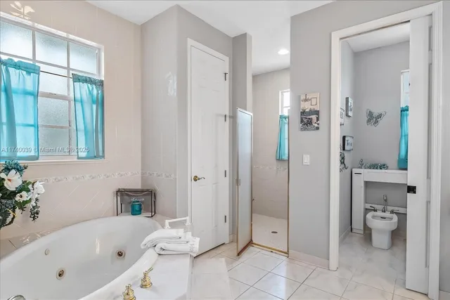 a bathroom with a tub shower and toilet