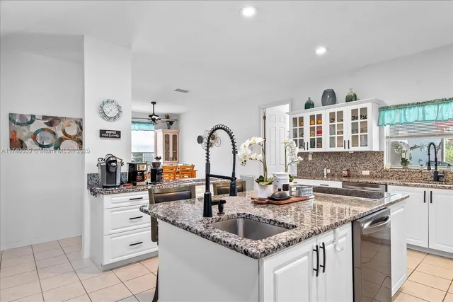 a kitchen with granite countertop a sink and cabinets