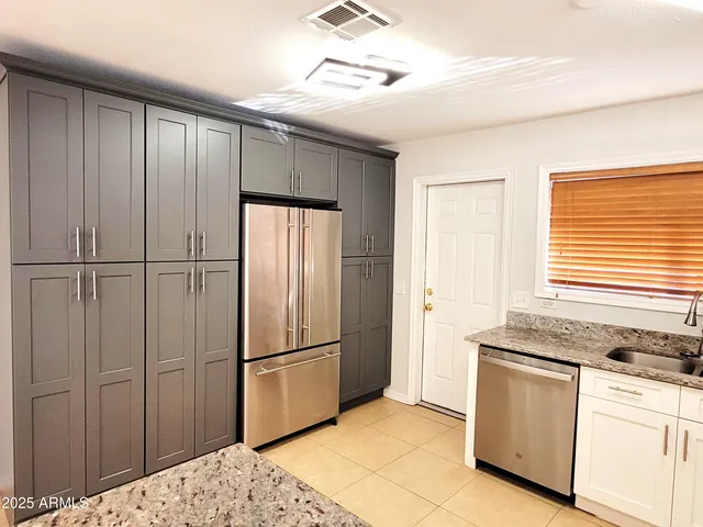 a kitchen with granite countertop a refrigerator and a sink