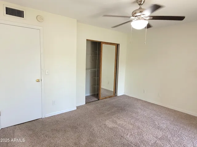 a view of a big room with a chandelier fan