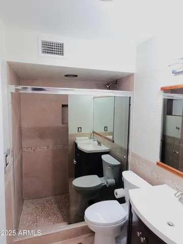 a bathroom with a sink a toilet and shower