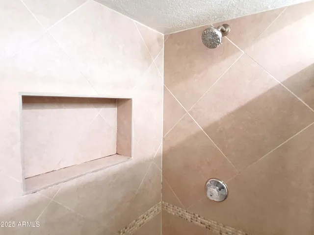 a bathroom with a granite countertop shower and a window