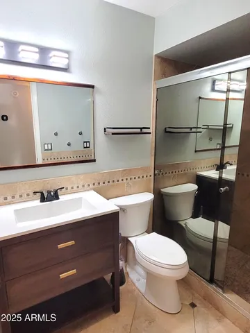 a bathroom with a sink a toilet and mirror