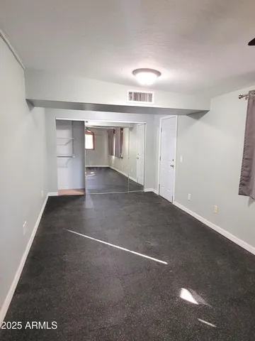 a view of a big room with windows and chandelier fan