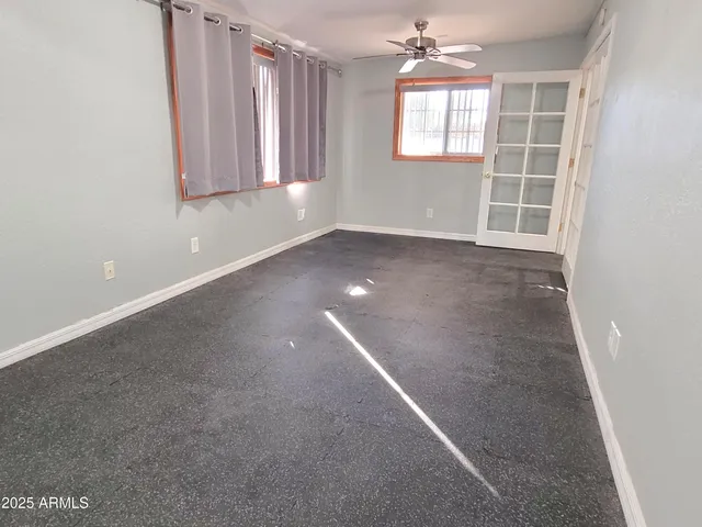 an empty room with windows and cabinet