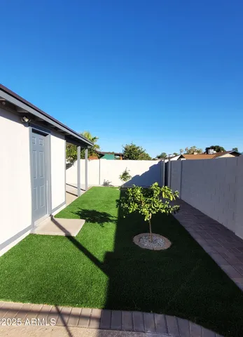 a view of a garden with a table & chairs
