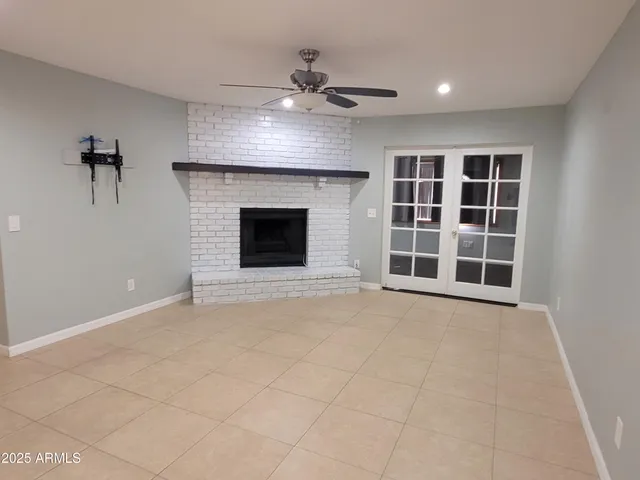 an empty room with windows and fireplace