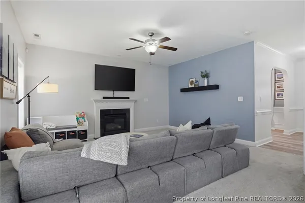 a living room with furniture a fireplace and a flat screen tv