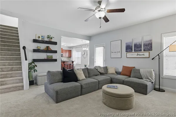 a living room with furniture and a view of kitchen