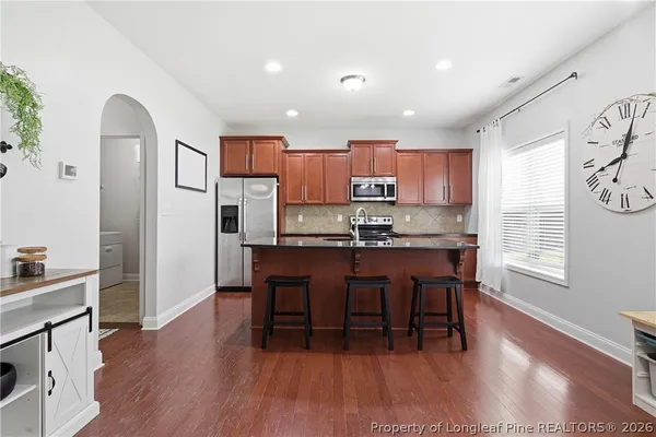 a kitchen with kitchen island granite countertop wooden floors and stainless steel appliances
