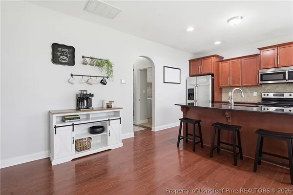 a kitchen with kitchen island stainless steel appliances a stove top oven a sink a counter space and cabinets