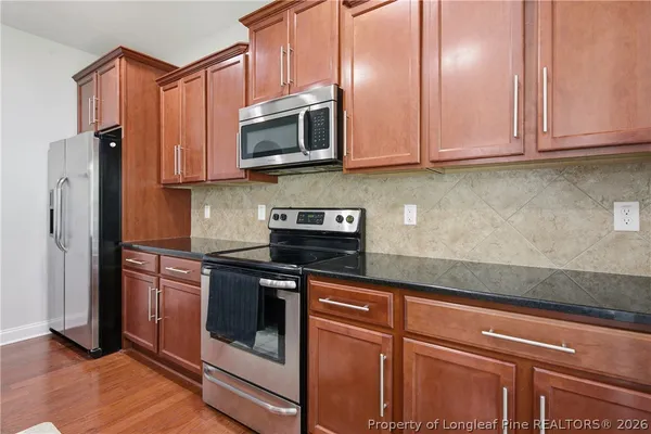 a kitchen with stainless steel appliances granite countertop a stove a microwave and a refrigerator