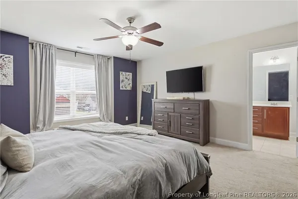 a spacious bedroom with a bed and a flat screen tv