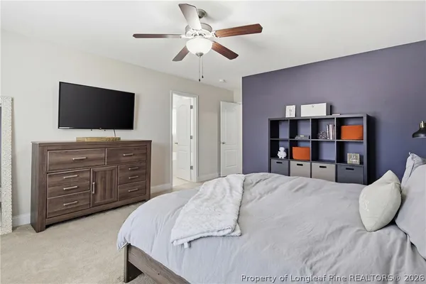 a bedroom with a bed a dresser and a flat screen tv