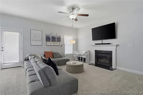 a living room with furniture a flat screen tv and a fireplace