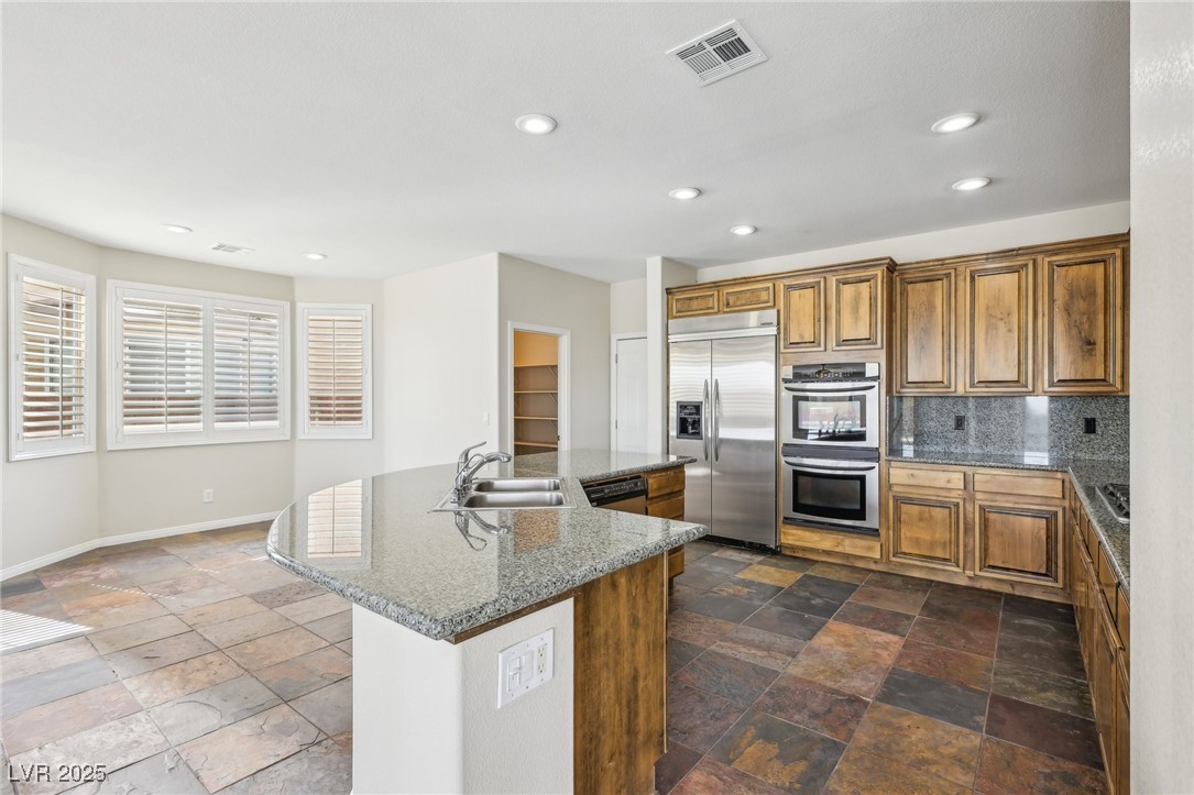 6188 Windfresh Drive Las Vegas, NV 89148 - Photo 24 of 94 Kitchen with visible vents, brown cabinets, applia