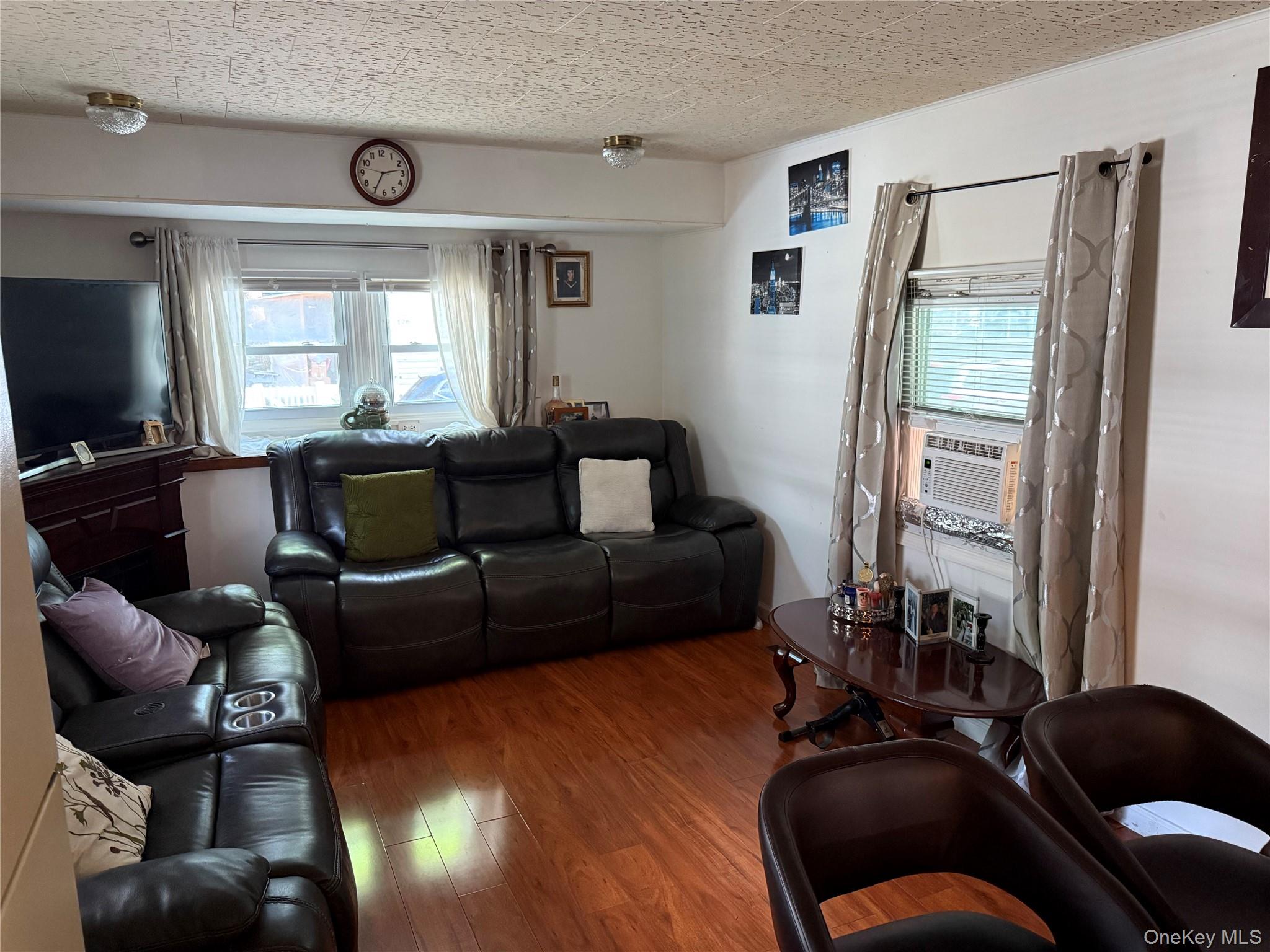 136 Quaker Rd Park Pomona, NY 10970 - Photo 8 of 24 Living area featuring wood-finish flooring, multiple windows, and flush-mount ceiling fixtures