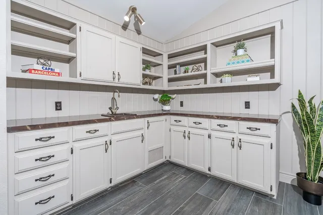 a kitchen with stainless steel appliances white cabinets and wooden floor