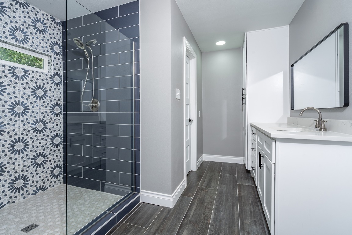 444 Logan Ranch Road Georgetown, TX 78628 - Photo 19 of 36 a bathroom with a sink a mirror and shower