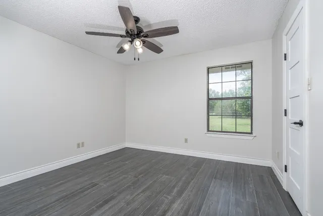 wooden floor in an empty room with a window