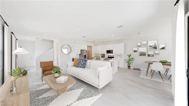 a living room with furniture and a dining table with potted plants
