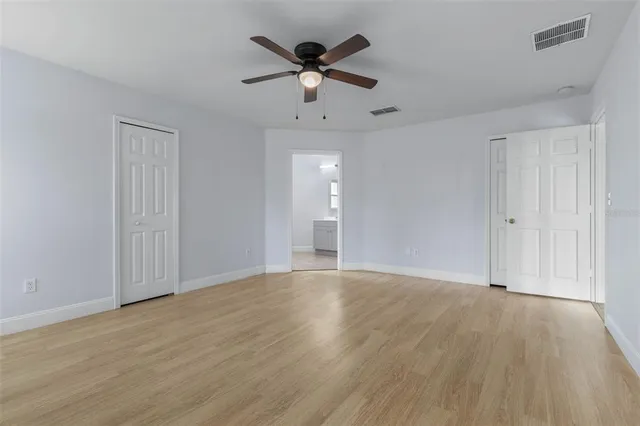 an empty room with fan and windows