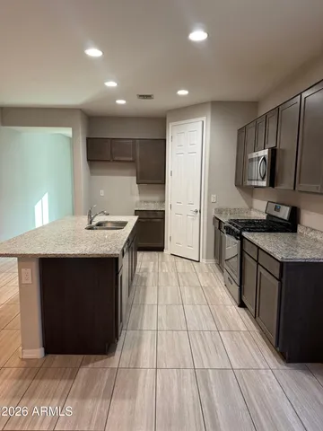 a kitchen with stainless steel appliances granite countertop a sink stove and refrigerator