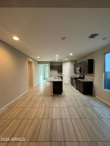 a view of kitchen with kitchen island granite countertop a sink and cabinets
