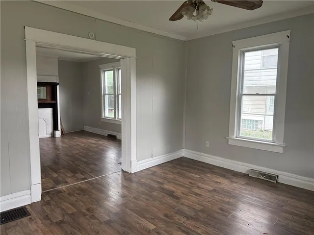 an empty room with wooden floor and windows