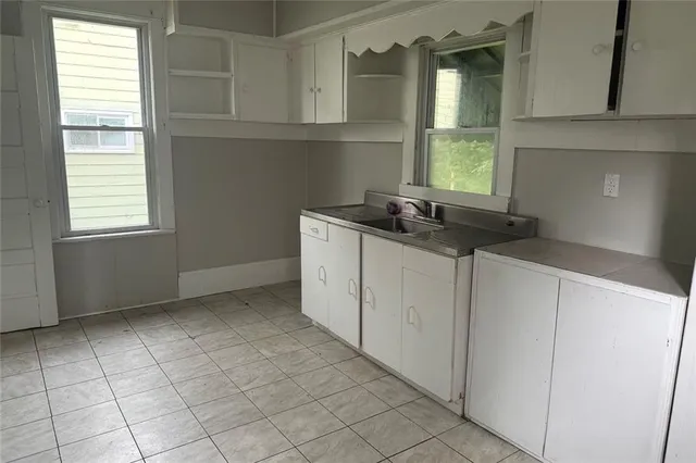 a kitchen with a sink a window and cabinets