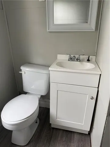 a white toilet sitting next to a white sink and vanity