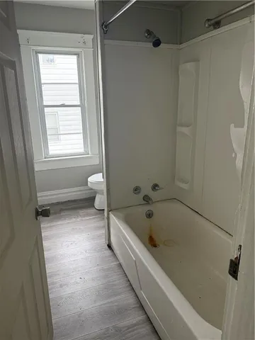 a bathroom with a tub a toilet and a shower