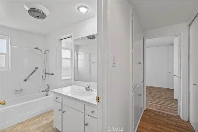 a bathroom with a tub sink shower and a mirror
