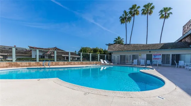 a view of a swimming pool with chair and tables