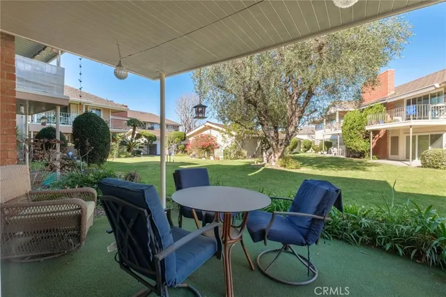 a view of a chairs and table in patio with a barbeque grill