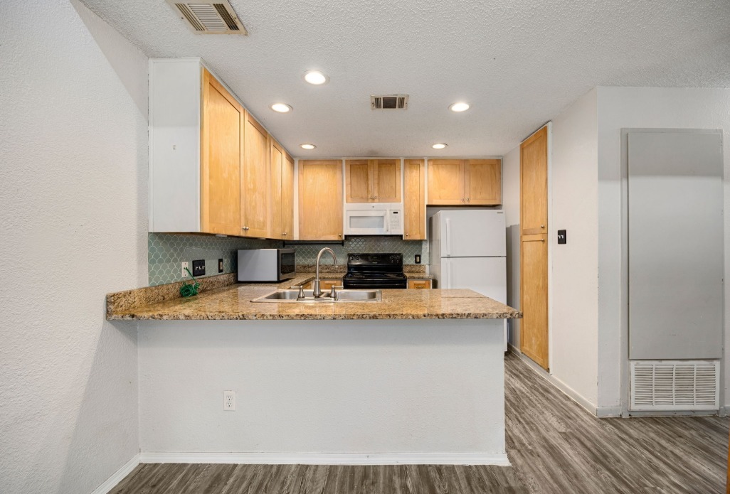 1748 Ohlen Road, Unit 42 Austin, TX 78757 - Photo 11 of 17 a kitchen with stainless steel appliances granite countertop a sink a refrigerator and a stove