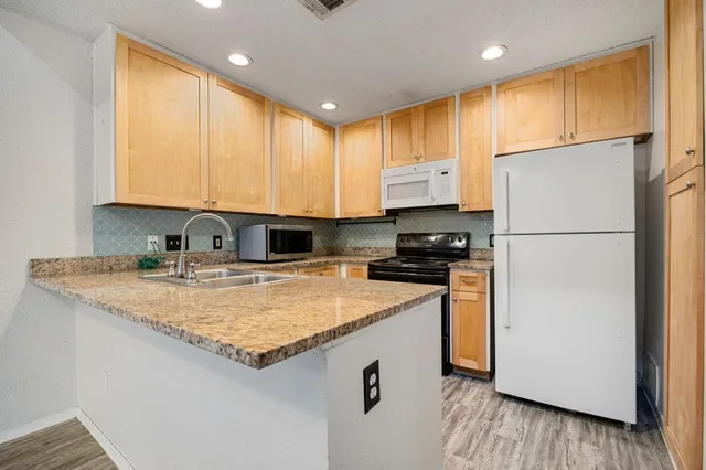a kitchen with a refrigerator sink and cabinets