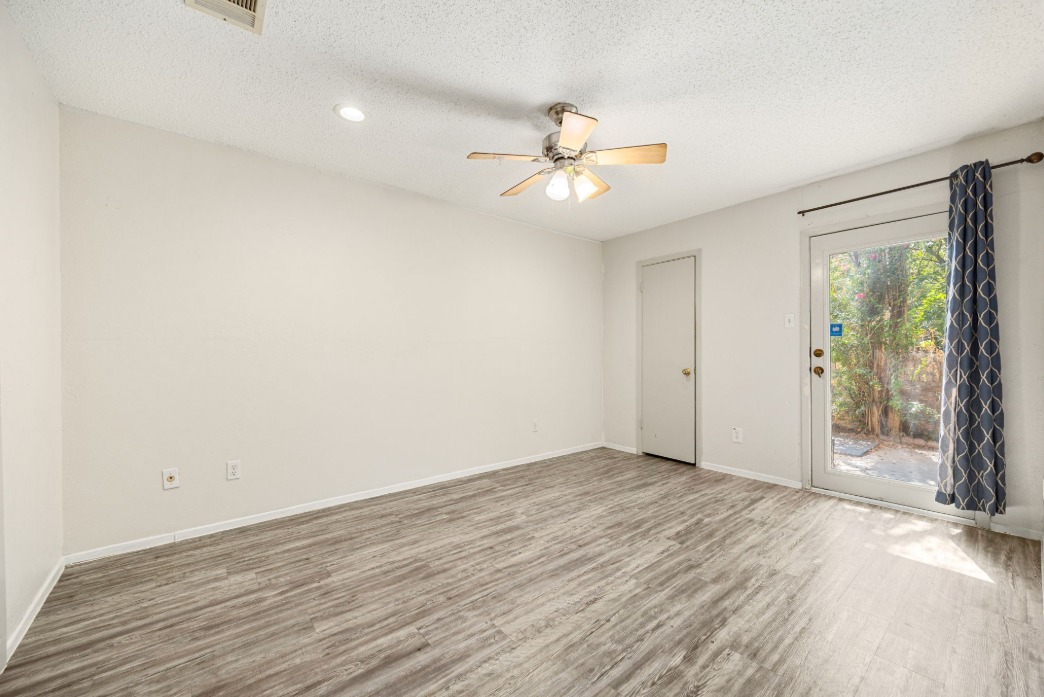 1748 Ohlen Road, Unit 42 Austin, TX 78757 - Photo 16 of 17 an empty room with wooden floor fan and windows