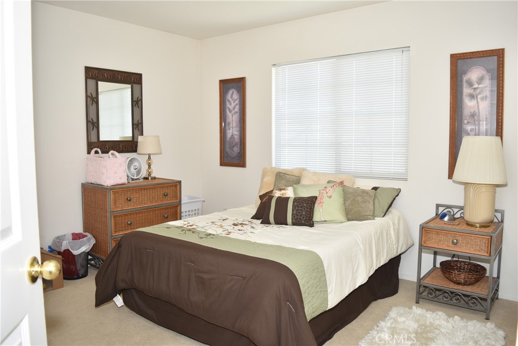 1665 Ravenswood Road Beaumont, CA 92223 - Photo 29 of 41 a bedroom with a bed and a lamp on dresser