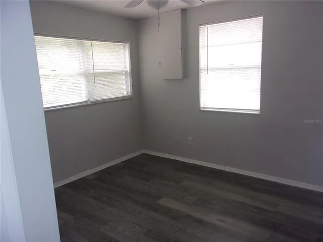 an empty room with wooden floor and a window