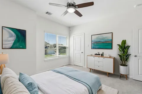 a bedroom with a bed potted plant on the dresser and a window