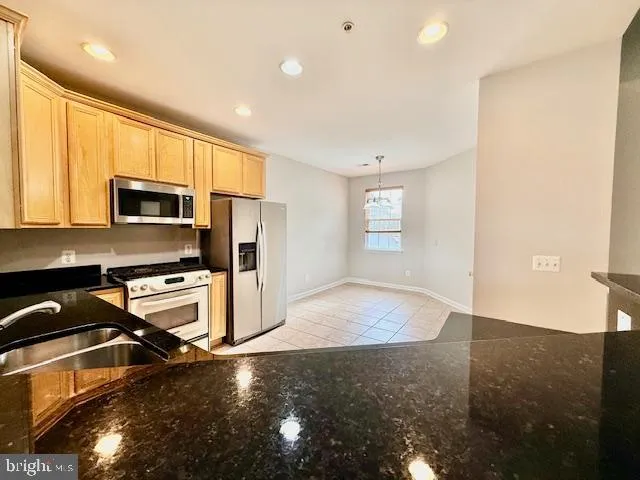 a kitchen with granite countertop a stove and a sink