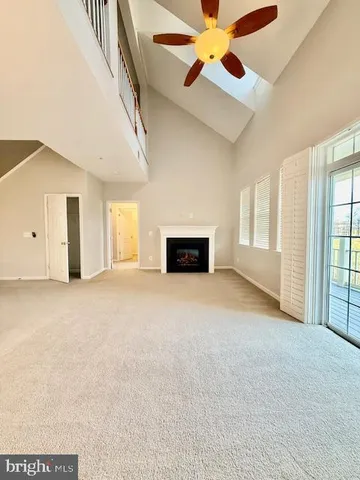 an empty room with windows and fireplace