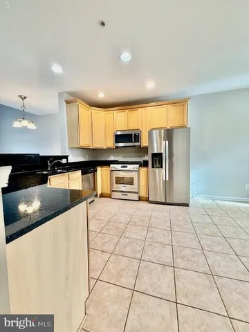 a kitchen with stainless steel appliances kitchen island granite countertop a sink and cabinets