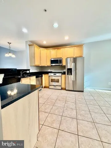 a kitchen with stainless steel appliances granite countertop a refrigerator sink and cabinets
