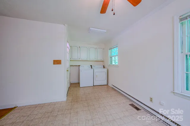 a view of storage and utility room with closet and windows
