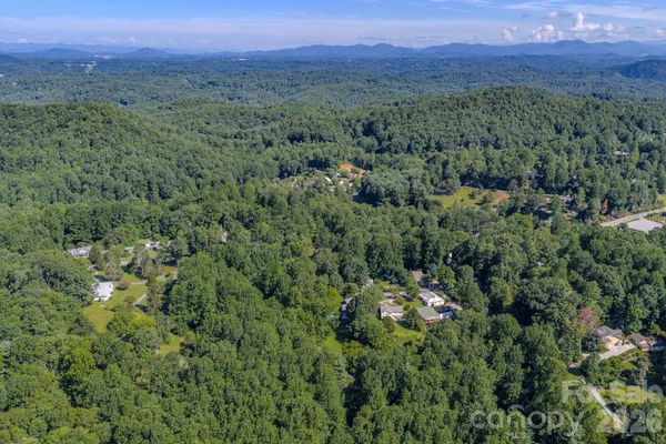 a view of a wooden house with a small yard and wooden fence
