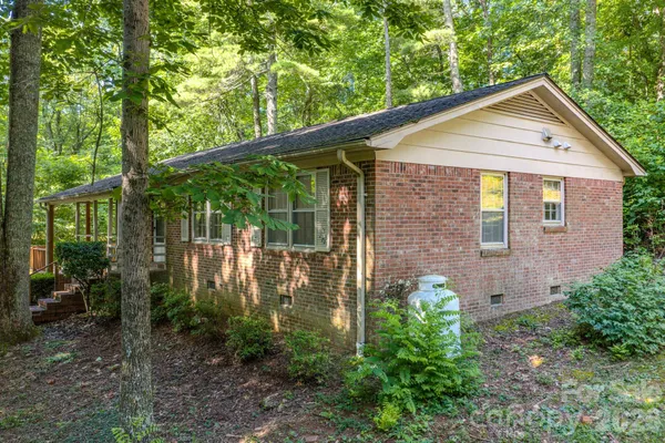 a view of a brick house with large windows and a yard
