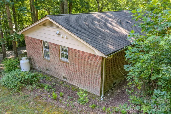 a aerial view of a house with a yard plants and large tree